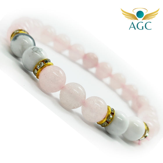 Rose Quartz and Howlite stretch bracelet shown diagonally, with pale pink beads, white and grey-veined beads, and gold-tone spacer rings